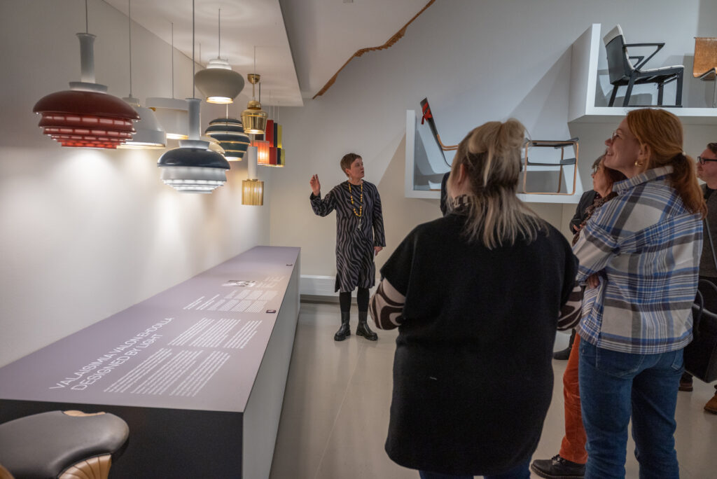 Opas esittelee Alvar Aallon valaisimia Aalto2-museokeskuksella